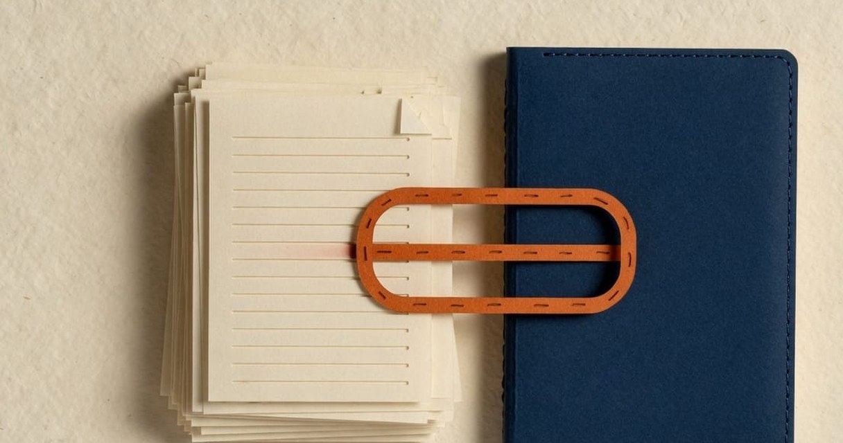 Paper-craft illustration: a fan of cream source cards — brief, transcript, report, contract, brand book — being slid into a navy notebook, with a dashed orange line counting them in.